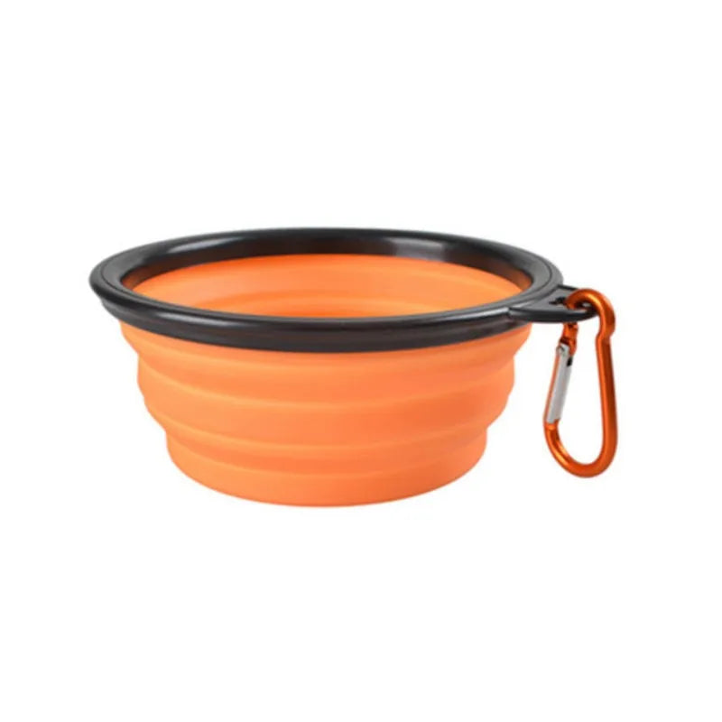 Orange collapsible dog bowl with black rim and carabiner on a white background