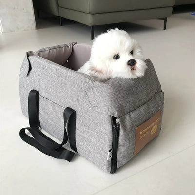 White dog inside a gray pet carrier on a light-colored floor.
