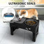Dog using a black elevated pet feeder with ultrasonic seals and splashproof design.