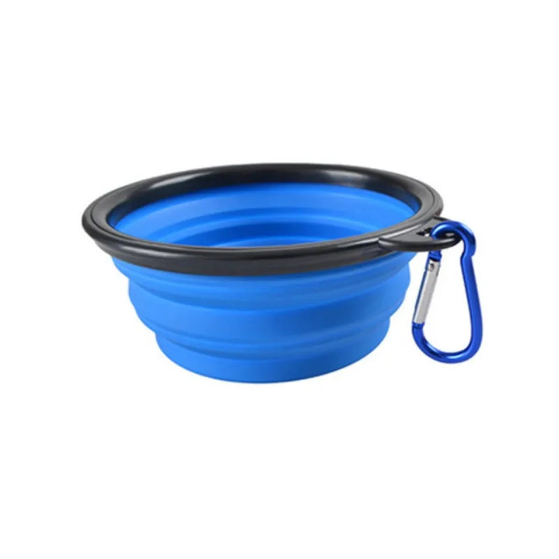Blue silicone travel bowl with black rim and blue carabiner on a white background