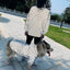 Person and dog wearing matching Pet Shield reflective raincoat, showing versatility for different pets.
