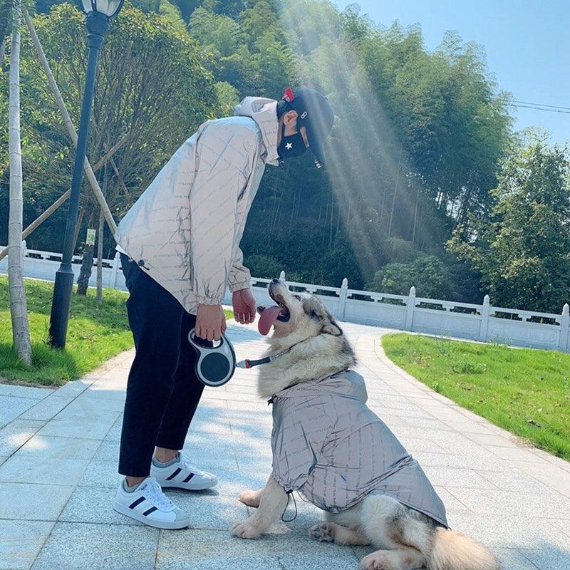 Dog enjoying the day with partner while staying completely dry in the Pet Shield waterproof pet coat.