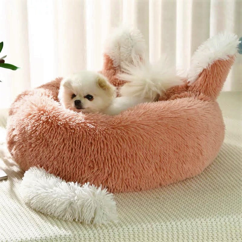 Small dog in a fluffy pink pet bed with white fur 