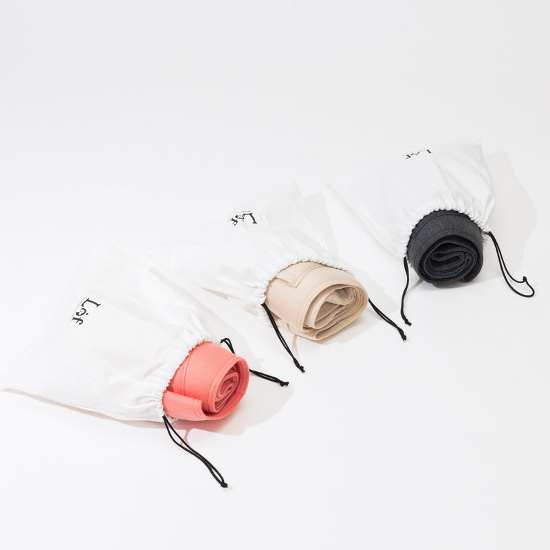 Set of three rolled-up towels in different colors on a white background