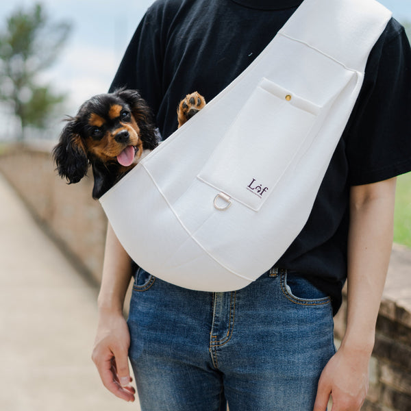 Person carrying a Small Pet Sling Carrier with a small dog