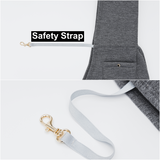 Gray dog leash with gold clip attached to a gray jacket, labeled 'Safety Strap'.