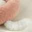 Close-up of a pink and white fluffy heart-shaped pillow 