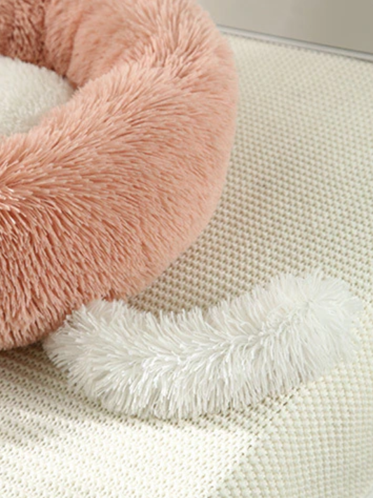 Close-up of a pink and white fluffy heart-shaped pillow 