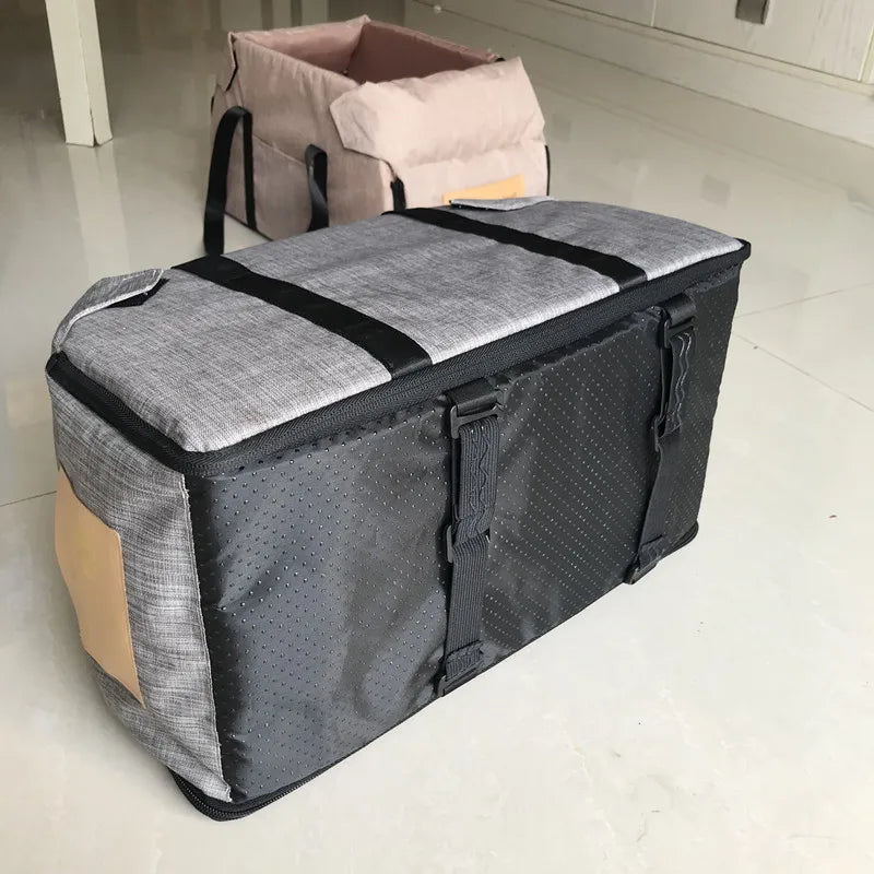 Large gray and black storage bag with straps on a light wooden floor.