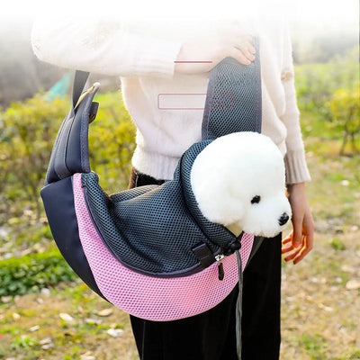 Person carrying a small white dog in a pink and black pet carrier outdoors.