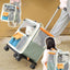 Pet carrier attached to a suitcase with a cat inside, being pulled by a person.