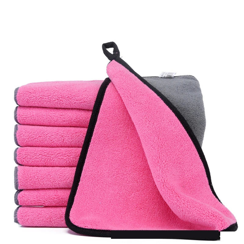 Stack of pink microfiber towels with a gray towel on a white background