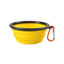 Yellow collapsible dog bowl with black rim and orange carabiner on a white background